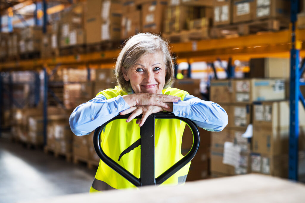 A woman with gray hair in a warehouse.